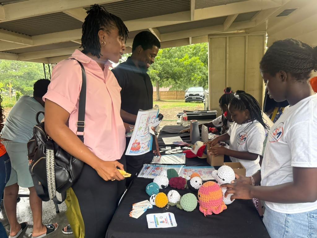 Founders interacting with visitors at a busy Market Day table